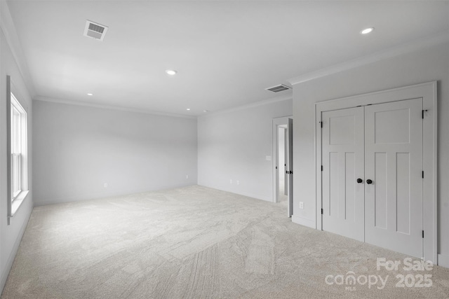 spare room featuring visible vents, crown molding, and light colored carpet