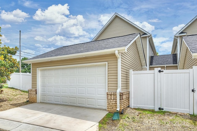 garage with driveway and fence