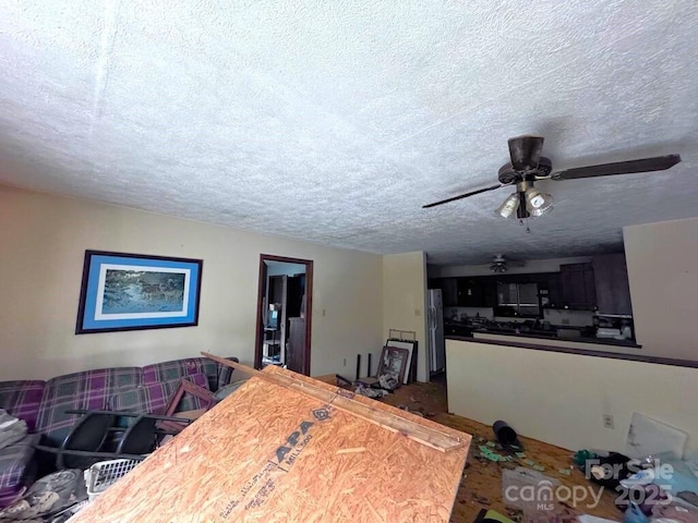 living room featuring a textured ceiling and a ceiling fan