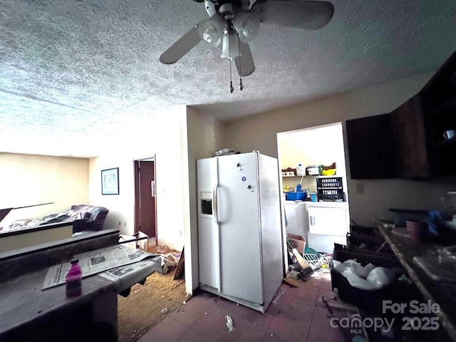 kitchen featuring white refrigerator with ice dispenser, ceiling fan, and a textured ceiling