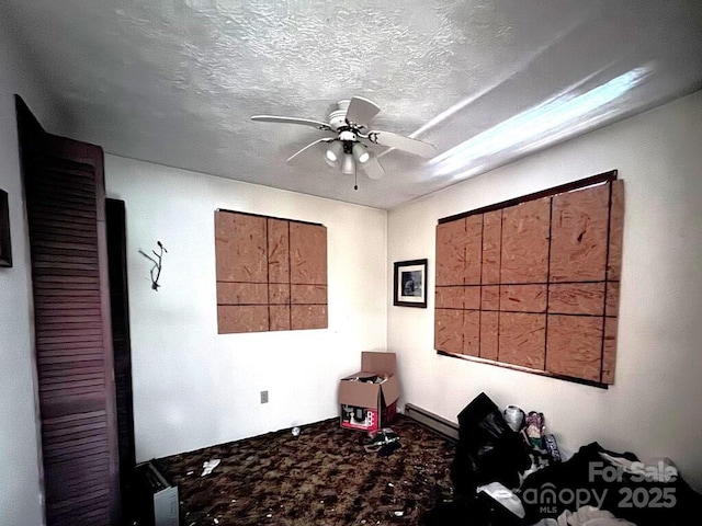 miscellaneous room with ceiling fan and a textured ceiling