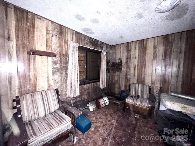 unfurnished room with wooden walls and a textured ceiling