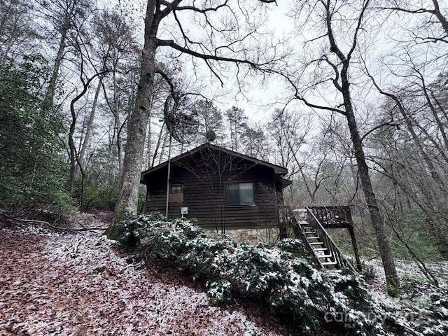 view of property exterior featuring stairs and a deck