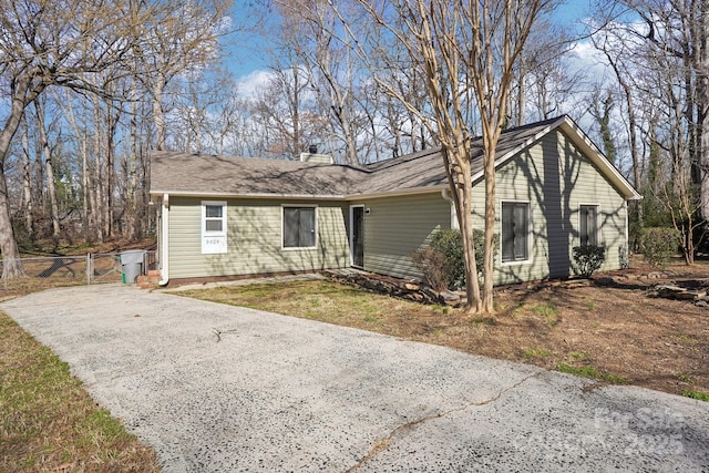 single story home with driveway and fence