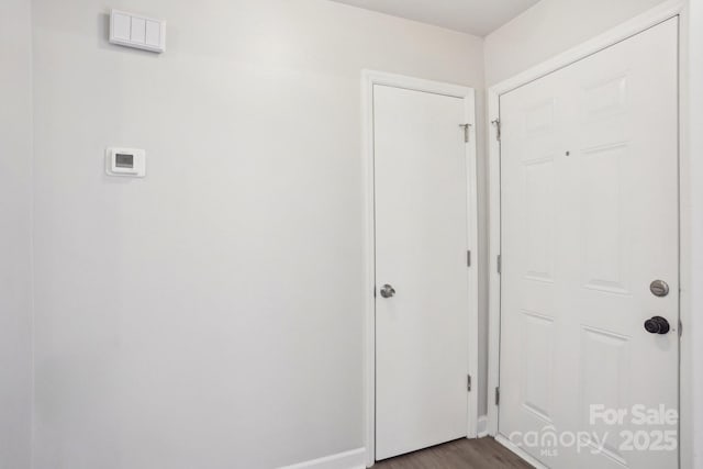 doorway to outside featuring dark wood-style flooring and baseboards