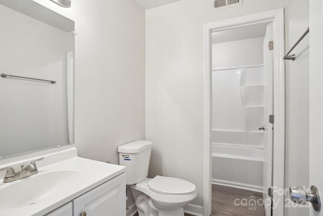 full bathroom featuring toilet, wood finished floors, vanity, and visible vents