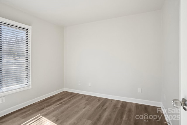 unfurnished room with baseboards and wood finished floors