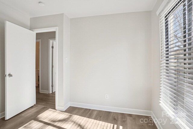 unfurnished bedroom with baseboards and wood finished floors