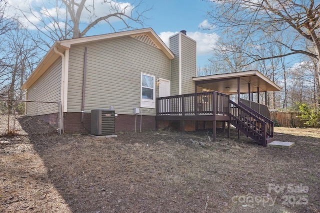 view of home's exterior with a chimney, stairway, fence, a wooden deck, and central AC