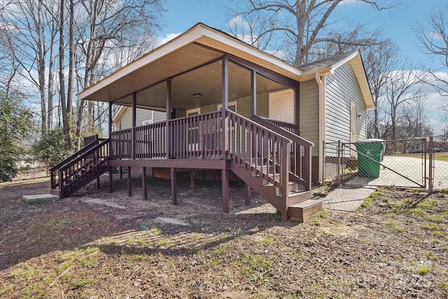 exterior space with a gate, fence, and stairway