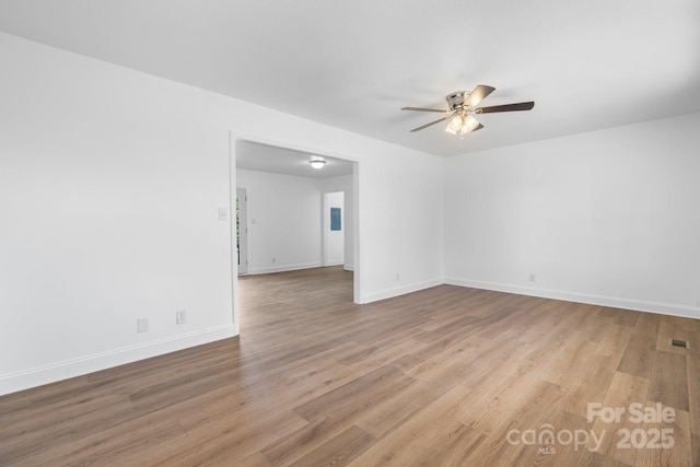 spare room with light wood-style flooring, visible vents, baseboards, and a ceiling fan