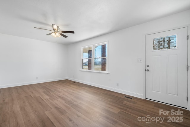 foyer entrance featuring ceiling fan, wood finished floors, visible vents, and baseboards