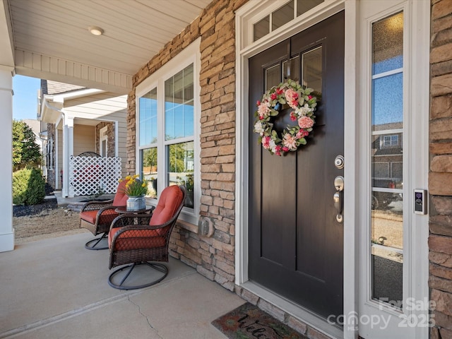 entrance to property with covered porch and brick siding