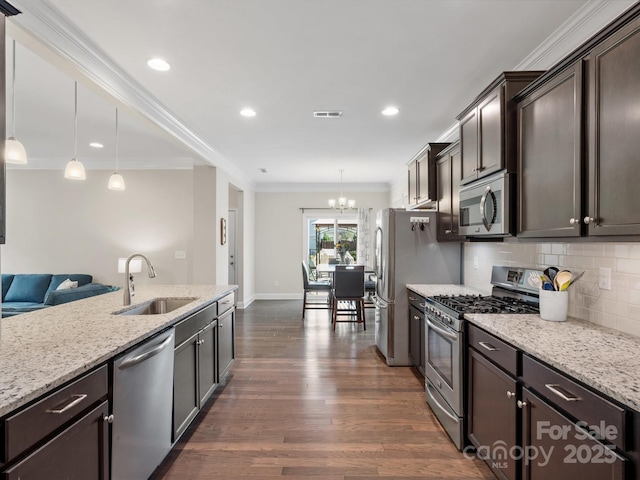 kitchen with stainless steel appliances, dark wood-type flooring, a sink, ornamental molding, and backsplash