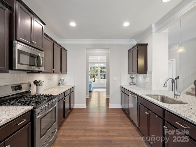 kitchen with ornamental molding, appliances with stainless steel finishes, a sink, and dark brown cabinetry