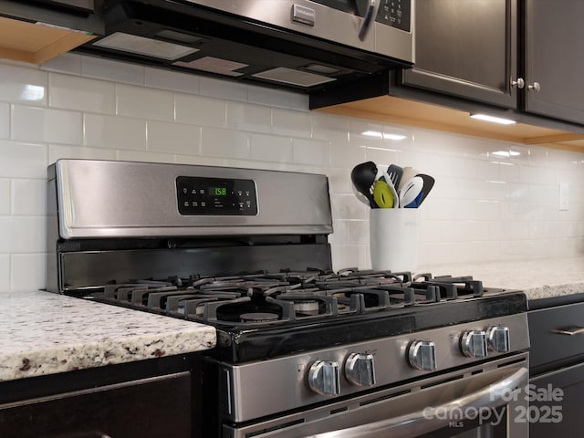 kitchen featuring light stone countertops, tasteful backsplash, and appliances with stainless steel finishes