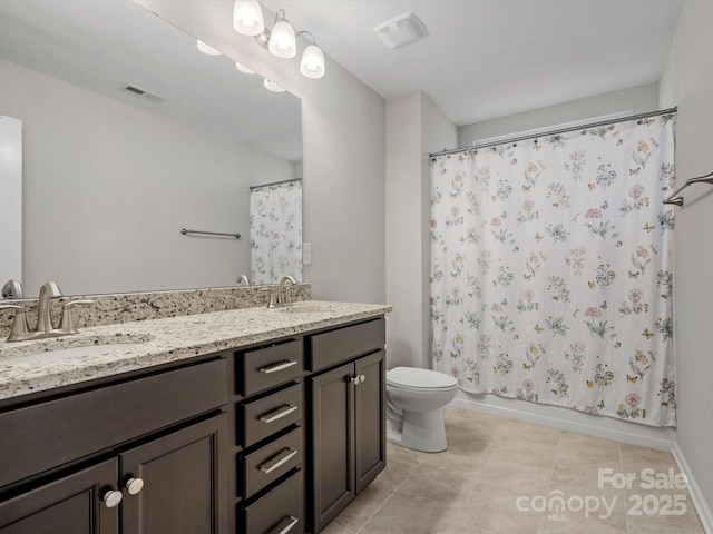 bathroom featuring visible vents, a sink, toilet, and double vanity