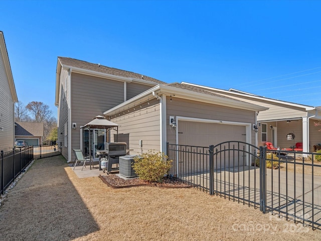 view of home's exterior with a garage, fence private yard, driveway, and a patio