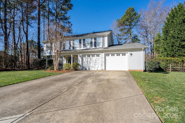 view of front of home with concrete driveway, a front lawn, an attached garage, and fence