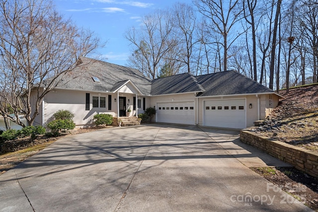 ranch-style home featuring a garage, concrete driveway, and stucco siding