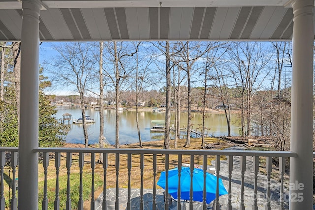 balcony with a water view and a dock