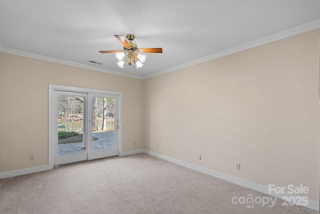 unfurnished room featuring light colored carpet, a ceiling fan, baseboards, visible vents, and crown molding