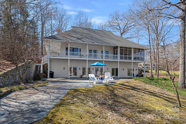 rear view of house featuring a yard, a patio, and driveway