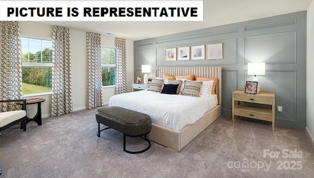 carpeted bedroom featuring baseboards and a decorative wall