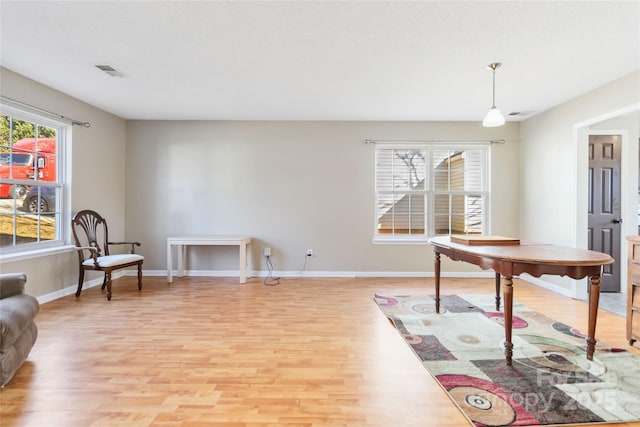 interior space featuring visible vents, light wood-style flooring, and baseboards