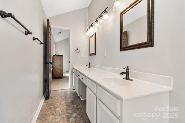 bathroom with lofted ceiling, double vanity, a sink, and baseboards