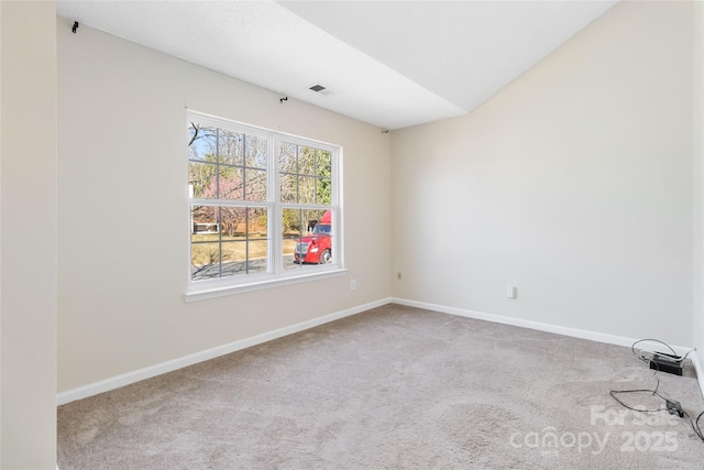 carpeted spare room featuring baseboards and visible vents