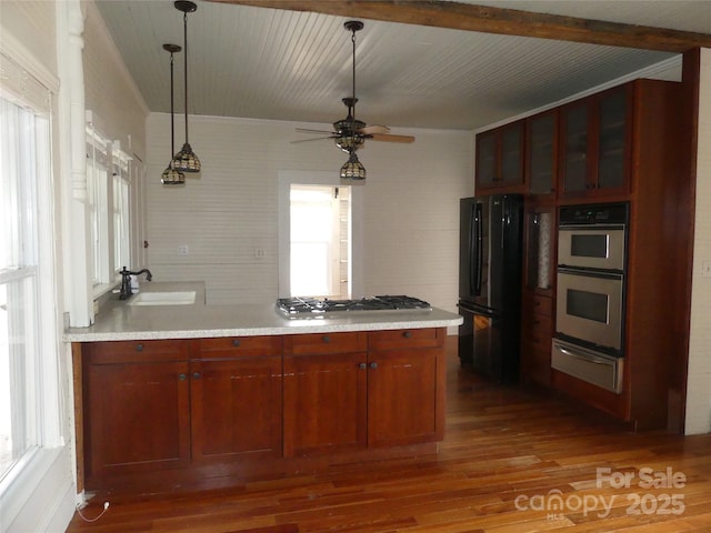 kitchen with dark wood-style floors, light countertops, stainless steel appliances, a sink, and a warming drawer