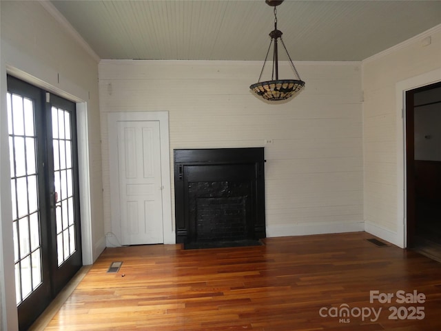 interior space with ornamental molding, french doors, wood finished floors, and visible vents