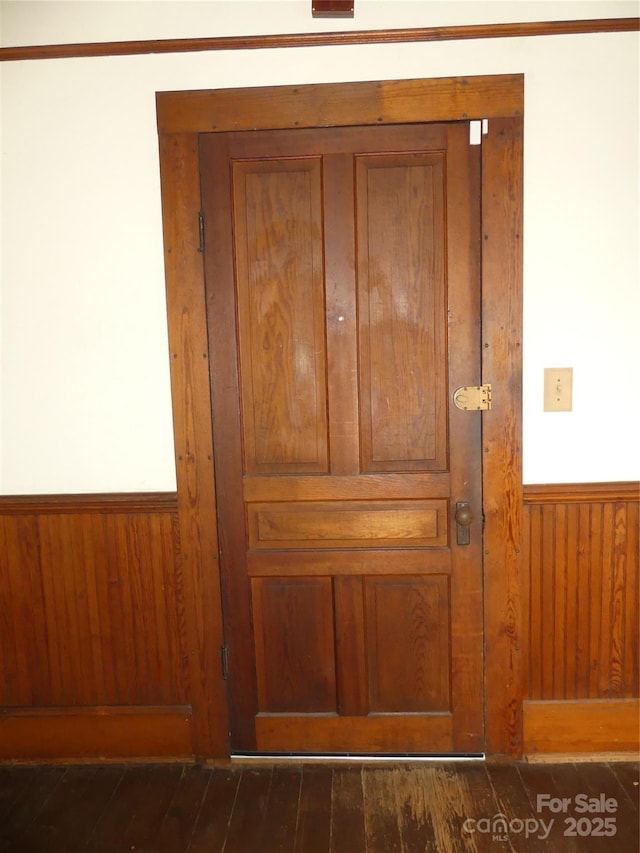 room details with a wainscoted wall, wood finished floors, and wood walls