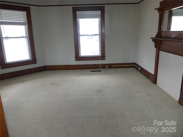 empty room featuring carpet and baseboards