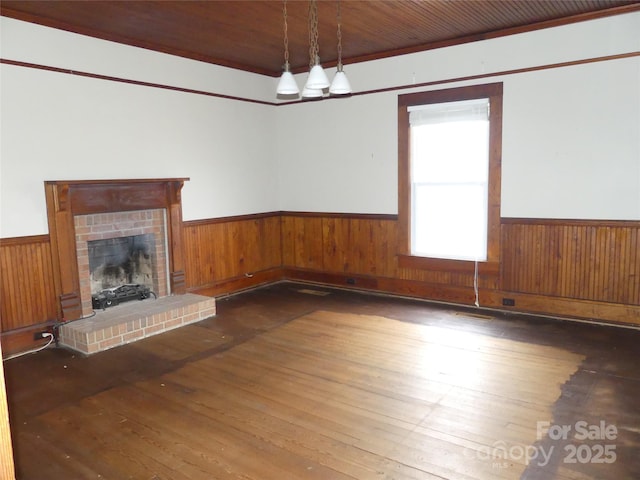 unfurnished living room featuring a wainscoted wall, hardwood / wood-style floors, wood walls, and wood ceiling