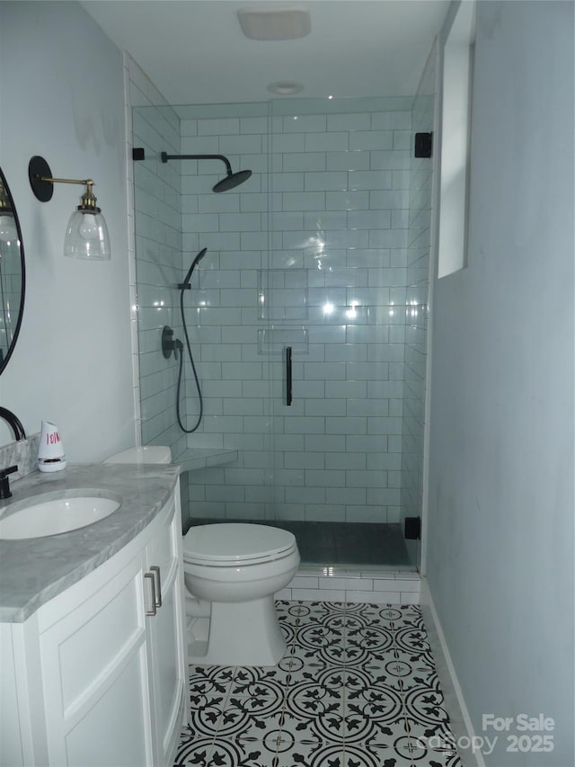 bathroom featuring toilet, tile patterned floors, a shower stall, and vanity