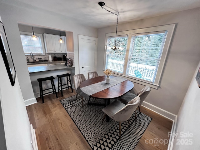 dining room with baseboards, a chandelier, and dark wood-type flooring