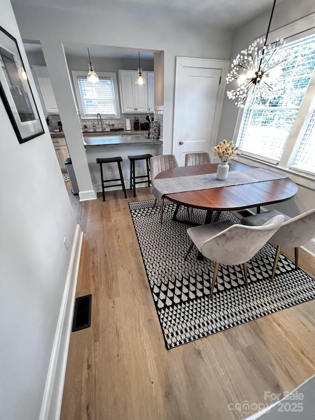 dining room with visible vents, baseboards, and wood finished floors