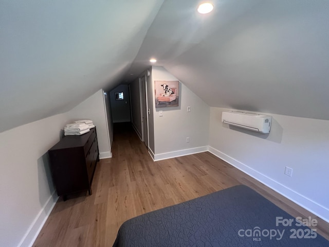 bonus room featuring baseboards, a wall unit AC, lofted ceiling, wood finished floors, and recessed lighting