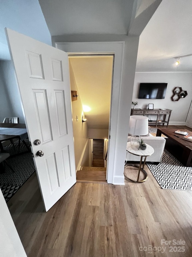 corridor with baseboards and wood finished floors