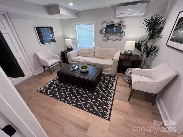 living area featuring a wall mounted AC, recessed lighting, wood finished floors, and baseboards