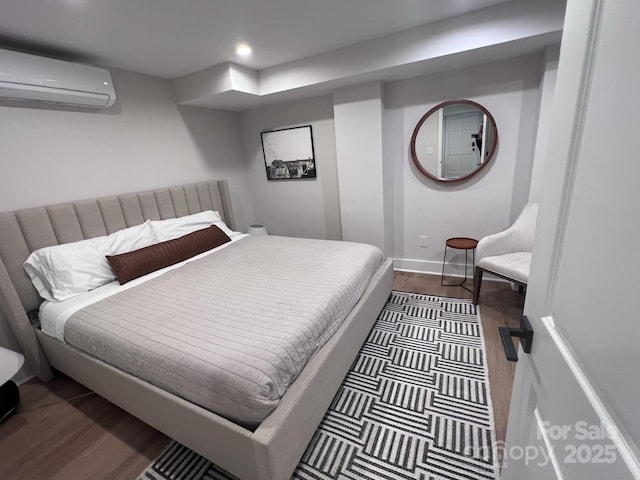 bedroom with recessed lighting, baseboards, an AC wall unit, and wood finished floors