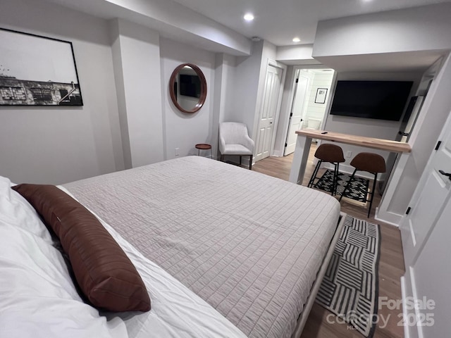 bedroom featuring baseboards, wood finished floors, and recessed lighting