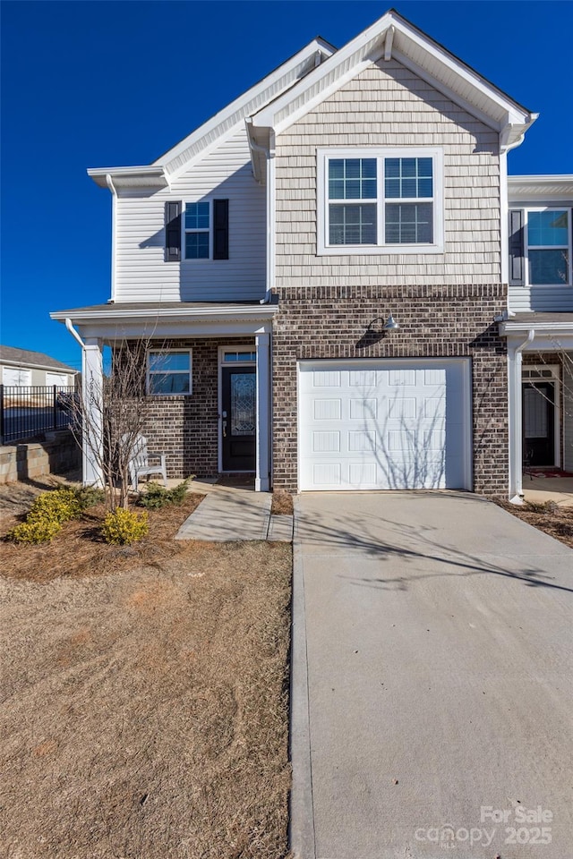 view of front of house featuring brick siding, driveway, and an attached garage