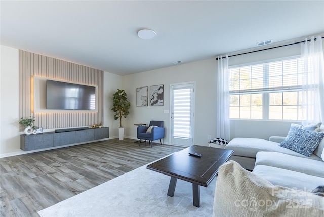 living area featuring visible vents, baseboards, and wood finished floors