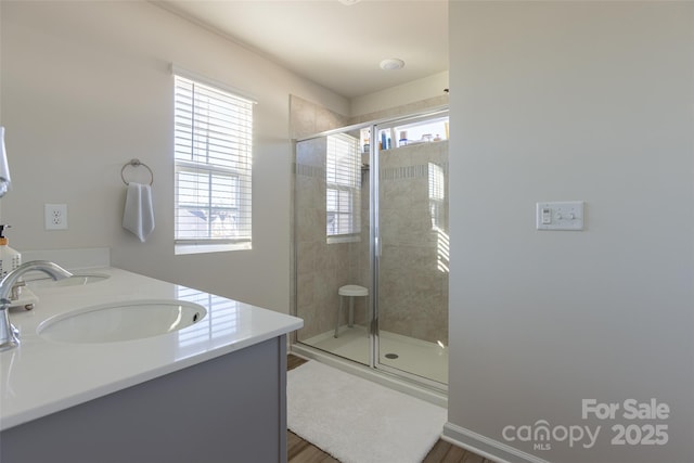 full bath featuring a stall shower, plenty of natural light, and a sink