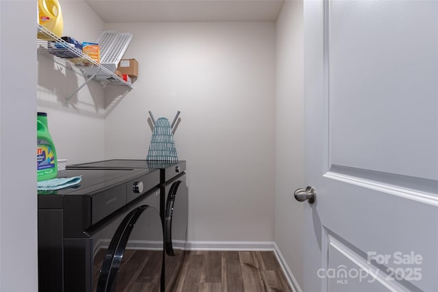 clothes washing area with laundry area, baseboards, washing machine and clothes dryer, and wood finished floors