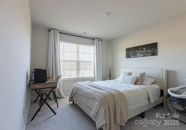 bedroom with visible vents and light carpet