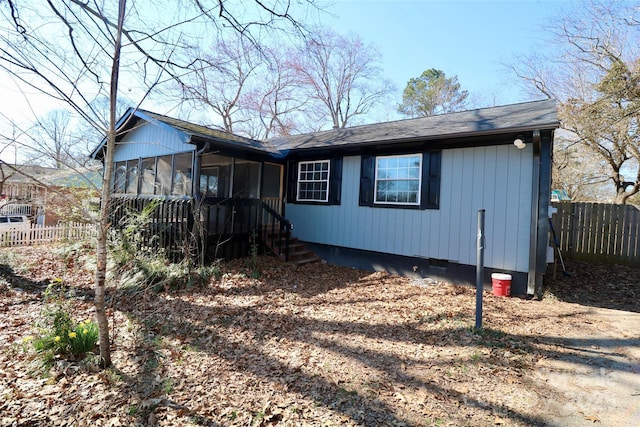 view of front of home with a sunroom and fence